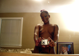 Tattoed young ebony taking pictures of..